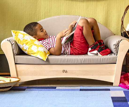 preschool boy reading books lying on kids sofa