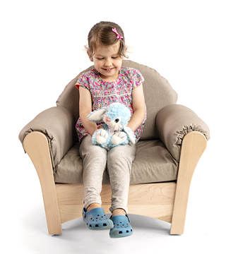 preschool girl reading in a child sized arm chair